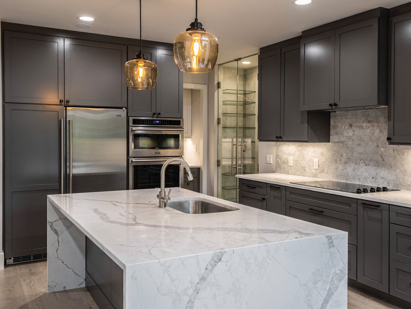 Expansive modern shaker kitchen near Smyrna Market Village showcasing dual quartz prep islands, professional range, and wide plank floors