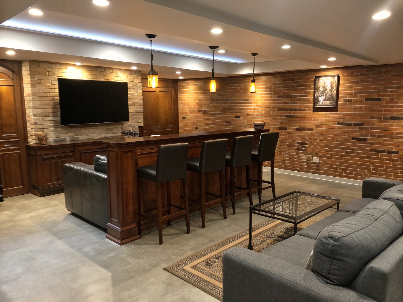 Basement walk-up pub with custom walnut bar counter, draft taps, and billiards table under warm pendant lighting