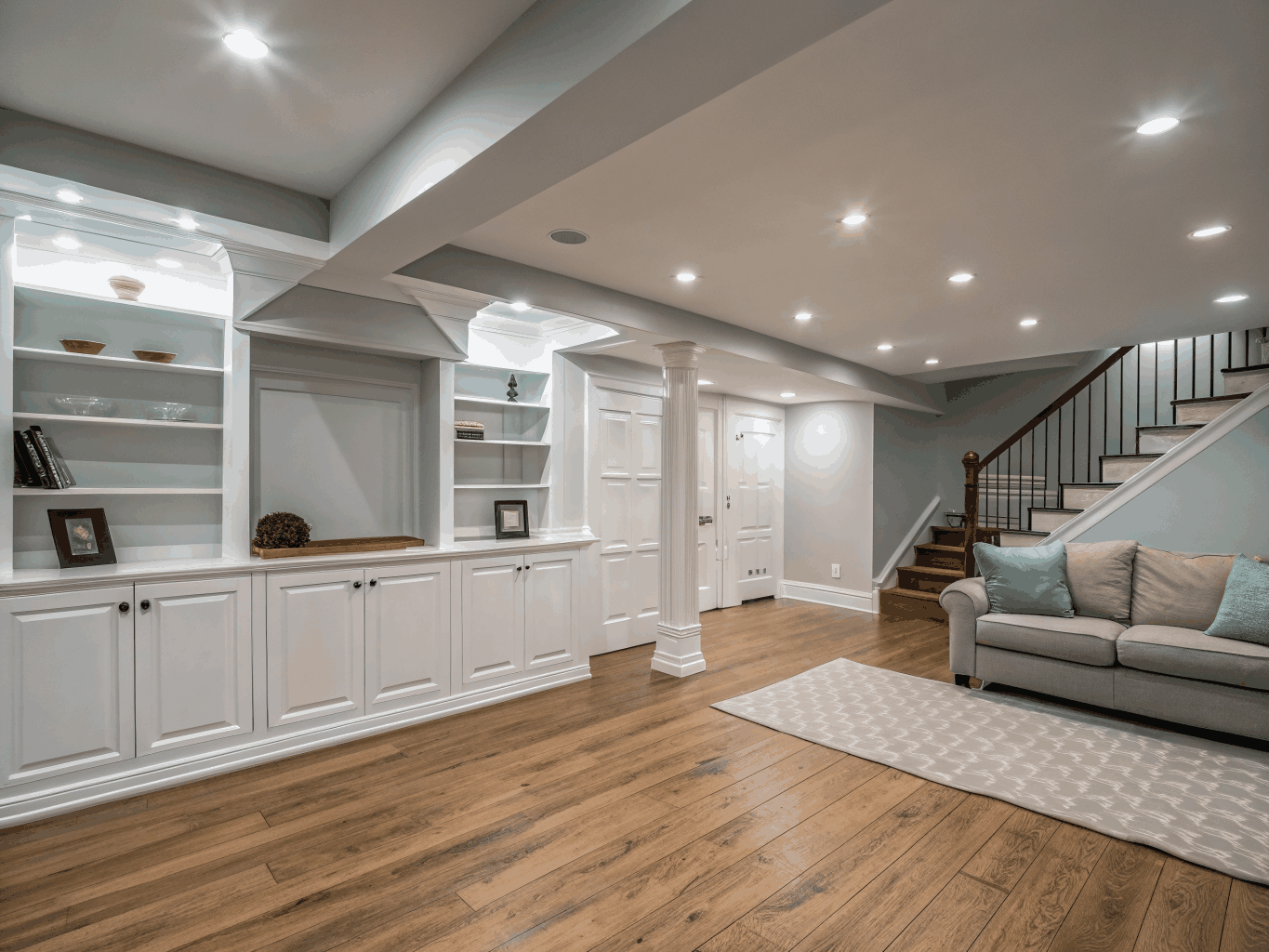 Spacious finished basement recreation room with built-in bunk beds, lounge seating, and craft area