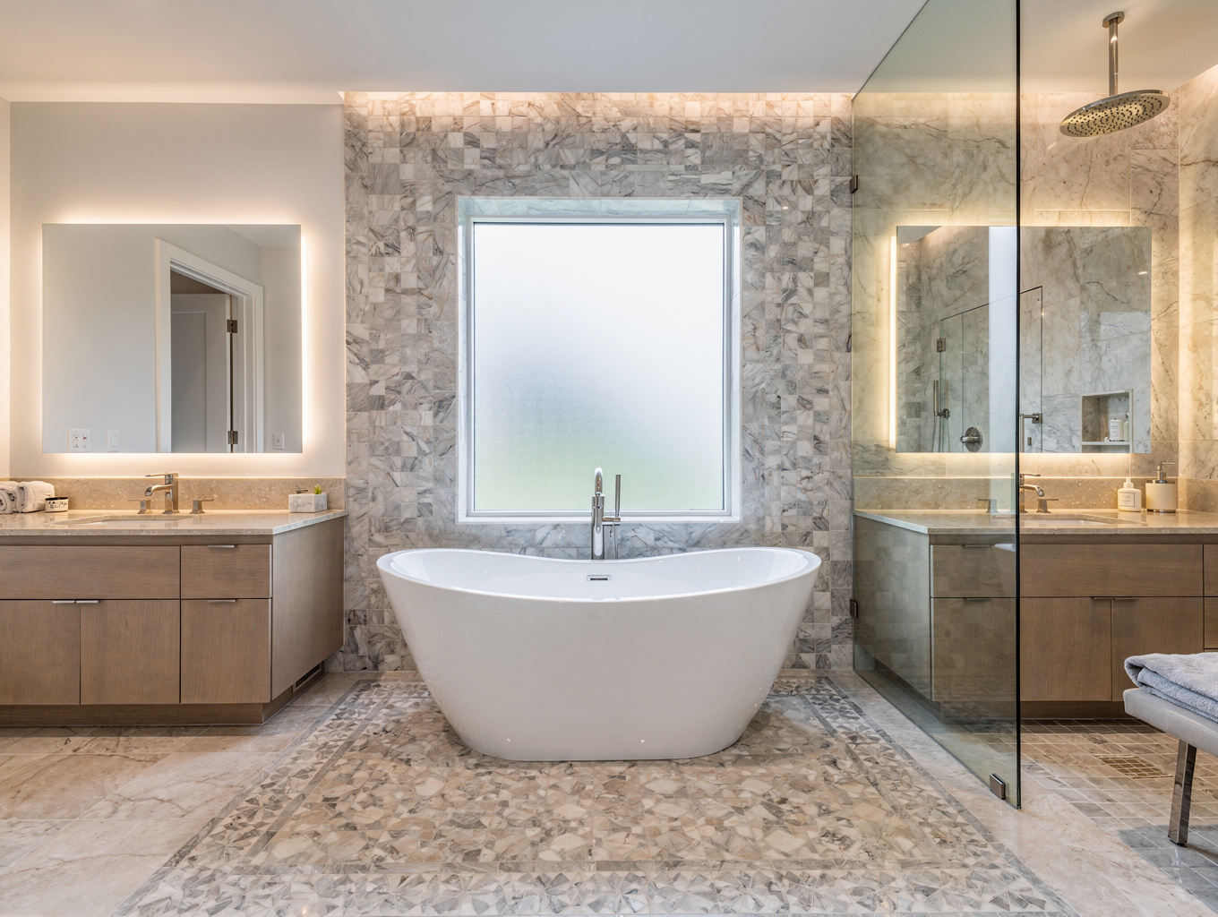 Spa-inspired luxury primary bathroom renovation with freestanding oval soaking tub, curbless glass walk-in shower, and rift-sawn oak fluted vanity